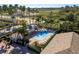 Community pool area featuring a covered lounge area, jacuzzi and sun loungers surrounded by palm trees at 14120 Whitecap Ave, Hudson, FL 34667