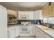 Bright kitchen with white cabinets, black tile backsplash, and a window above the sink at 14120 Whitecap Ave, Hudson, FL 34667