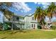 Two-story light teal home with outdoor staircase at 3207 Hibiscus Dr, Hernando Beach, FL 34607