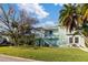 Two-story light teal home with stairs and palm trees at 3207 Hibiscus Dr, Hernando Beach, FL 34607
