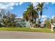 Two-story house with palm trees, green exterior, and a large yard at 3207 Hibiscus Dr, Hernando Beach, FL 34607