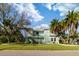 Two-story house with palm trees, green exterior, and a large yard at 3207 Hibiscus Dr, Hernando Beach, FL 34607