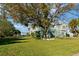 Large grassy yard with mature tree and home view at 3207 Hibiscus Dr, Hernando Beach, FL 34607