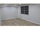Simple bedroom with gray walls, wood-look flooring, and a window at 3518 Moog Rd, Holiday, FL 34691