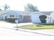 House exterior featuring light teal siding, brick accents, and a two-car garage at 3518 Moog Rd, Holiday, FL 34691