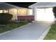 Well-lit home exterior featuring a brick facade and driveway at 3518 Moog Rd, Holiday, FL 34691
