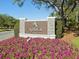 The Ardea Country Club community sign is surrounded by vibrant pink flowers on a sunny day at 4886 Westchester Ct, Oldsmar, FL 34677