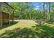 Spacious, fenced backyard featuring lush lawn and mature trees providing a private, serene outdoor space at 6051 Valley Spring Dr, Brooksville, FL 34601