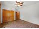 Bright bedroom featuring neutral paint, brick floors, a ceiling fan, and natural wood trim at 6051 Valley Spring Dr, Brooksville, FL 34601