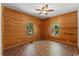 Spacious bedroom featuring natural wood walls, brick floors and two windows providing ample light at 6051 Valley Spring Dr, Brooksville, FL 34601