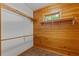 Walk-in closet with wooden shelving and window providing natural light and ventilation at 6051 Valley Spring Dr, Brooksville, FL 34601