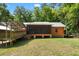 View of the back of the home with a screened-in porch, connected by a covered walkway, and a spacious backyard at 6051 Valley Spring Dr, Brooksville, FL 34601