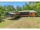 Exterior view of the home with a screened porch, connected by a covered walkway, and a spacious backyard at 6051 Valley Spring Dr, Brooksville, FL 34601