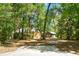 Secluded home exterior featuring natural wood and neutral paint surrounded by mature trees and a paved driveway at 6051 Valley Spring Dr, Brooksville, FL 34601