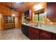 Spacious kitchen features wood cabinetry, brick-patterned floors, and a double sink at 6051 Valley Spring Dr, Brooksville, FL 34601