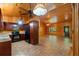 Open-concept view of kitchen with wood paneling, black appliances and brick-patterned floor at 6051 Valley Spring Dr, Brooksville, FL 34601