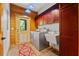 Charming laundry room with wood paneled walls, brick floors, and front loading washer and dryer at 6051 Valley Spring Dr, Brooksville, FL 34601