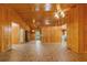Spacious open-plan living room with wood paneling, ceiling fans and neutral flooring at 6051 Valley Spring Dr, Brooksville, FL 34601