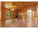 Well-lit living room with wood paneling, brick-patterned flooring, and views to a bathroom at 6051 Valley Spring Dr, Brooksville, FL 34601