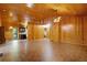 Open living room featuring wood paneling, brick-patterned flooring, and a view into the kitchen at 6051 Valley Spring Dr, Brooksville, FL 34601