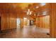Large living room with wood paneling, brick-patterned flooring, and access to other rooms at 6051 Valley Spring Dr, Brooksville, FL 34601