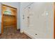 Bathroom stall shower with wood accent wall through doorway with small window at 6051 Valley Spring Dr, Brooksville, FL 34601