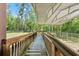 Exterior wooden walkway and ramp offer access to the home's covered porch and a view of the surrounding fenced-in yard at 6051 Valley Spring Dr, Brooksville, FL 34601