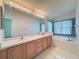 Bathroom featuring double sinks, large mirror, soaking tub, and wallpaper at 9519 Green Needle Dr, New Port Richey, FL 34655