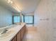Bathroom featuring double sinks, large mirror, soaking tub, and wallpaper at 9519 Green Needle Dr, New Port Richey, FL 34655