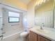 Bright bathroom featuring a shower-tub combo with safety bars and window for natural light at 9519 Green Needle Dr, New Port Richey, FL 34655