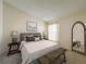 Staged bedroom with a decorative bed, matching side tables, and a mirror at 9519 Green Needle Dr, New Port Richey, FL 34655