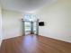 Well-lit bedroom featuring wood floors and a large window with curtains at 9519 Green Needle Dr, New Port Richey, FL 34655