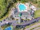 Aerial view of the community clubhouse, showcasing the pool, parking and tennis courts at 9519 Green Needle Dr, New Port Richey, FL 34655