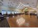 Expansive event space with hardwood floors, a stage, and a fireplace offers an elegant setting for various gatherings and events at 9519 Green Needle Dr, New Port Richey, FL 34655