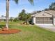 Home with a large front yard, mature palm trees, and neutral colored exterior at 11532 Holly Ann Dr, New Port Richey, FL 34654