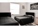 Well lit bedroom featuring two beds, large window, and bicycle themed decor on the wall at 12149 Chapman Ave, Port Charlotte, FL 33953