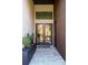 Modern home entryway with double doors, grey tiled floor, accent wall and manicured landscaping at 12149 Chapman Ave, Port Charlotte, FL 33953