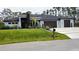 Attractive home exterior with a well-manicured lawn, modern driveway, and minimalist landscaping at 12149 Chapman Ave, Port Charlotte, FL 33953