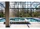 Screened-in pool area with hot tub and spacious deck overlooking a wooded area at 12149 Chapman Ave, Port Charlotte, FL 33953