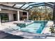 Outdoor screened-in pool and spa area with an outdoor kitchen and plenty of lounge seating at 12149 Chapman Ave, Port Charlotte, FL 33953