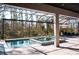 Screened-in pool area features a pool, spa, lounge chairs, and wooded backyard view at 12149 Chapman Ave, Port Charlotte, FL 33953