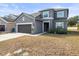Gray two-story home with manicured yard, attached garage, and sidewalk leading to the front door at 14143 Wake Robin Dr, Brooksville, FL 34604