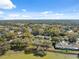 Panoramic aerial view featuring numerous homes nestled amidst mature trees and a tranquil lake at 7414 Heather Walk Dr, Weeki Wachee, FL 34613