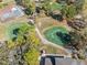 Overhead shot of a tennis court and green, showcasing community recreational amenities at 7414 Heather Walk Dr, Weeki Wachee, FL 34613