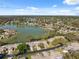 Overhead view of a charming neighborhood surrounding a serene lake under a blue sky at 7414 Heather Walk Dr, Weeki Wachee, FL 34613