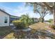 Backyard view with sunroom, beautiful landscaping, and a glimpse of the lake at 7414 Heather Walk Dr, Weeki Wachee, FL 34613