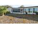 Enclosed sunroom and patio with lush landscaping enhance the backyard appeal at 7414 Heather Walk Dr, Weeki Wachee, FL 34613