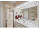 Well-lit bathroom with a shower, large mirror, and a single sink vanity at 7414 Heather Walk Dr, Weeki Wachee, FL 34613