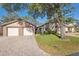 Charming single-story home with a brick driveway, two-car garage and mature trees at 7414 Heather Walk Dr, Weeki Wachee, FL 34613