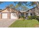 Beautiful single-story home with a brick driveway, two-car garage, green lawn, and mature trees at 7414 Heather Walk Dr, Weeki Wachee, FL 34613